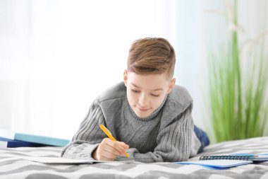 Sevimli genç yatağında ödev