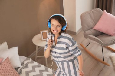 Evde güzel çift birlikte. Yatakta yatarken onu adam kulaklıklarla dans kadın