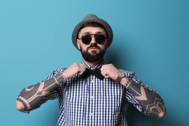 Renk arka plan üzerinde şık kıyafeti yakışıklı hipster portresi