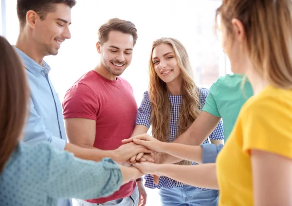 Los jóvenes se unieron en círculo sobre fondo blanco. Concepto de unidad — Foto de Stock