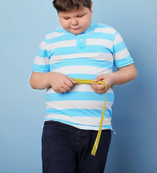 Overgewicht jongen met vloer weegschalen en Hamburger op witte achtergrond — Stockfoto