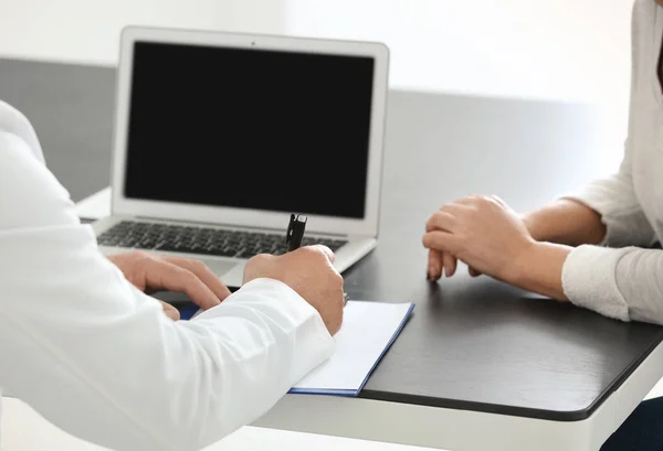 Male doctor consulting patient in clinic — Stock Photo, Image