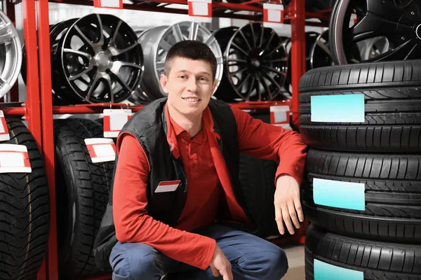 Mecânico masculino com pneus de carro na loja — Fotografia de Stock