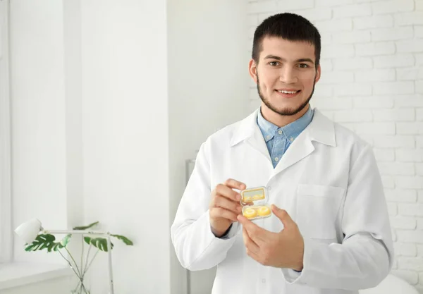 Läkaren håller plastbehållare med kontaktlinser i kliniken — Stockfoto