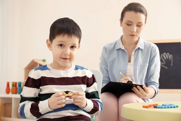 Schattige kleine jongen met zijn moeder leesboek thuis in avond — Stockfoto