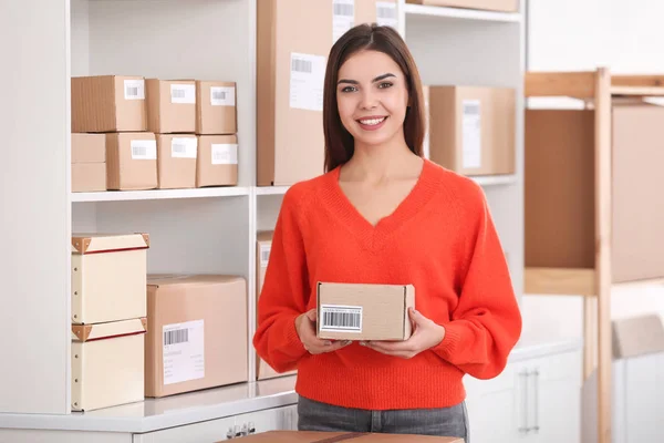 Jovem mulher preparando parcela — Fotografia de Stock