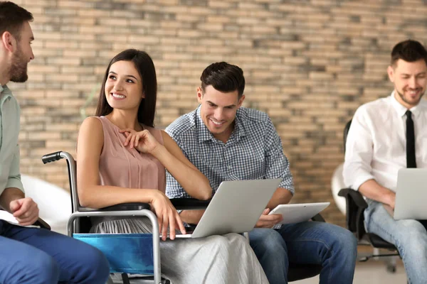 Woman in wheelchair with colleagues — Stock Photo, Image