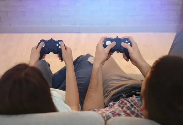 若いカップルのソファーに座っていると自宅でビデオ ゲームをプレイ — ストック写真