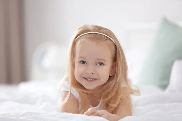 Klein meisje liggend op bed — Stockfoto