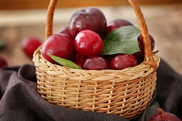 Wicker basket with plums — Stock Photo, Image