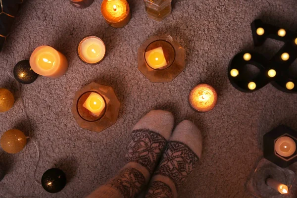 Woman in socks standing near candles