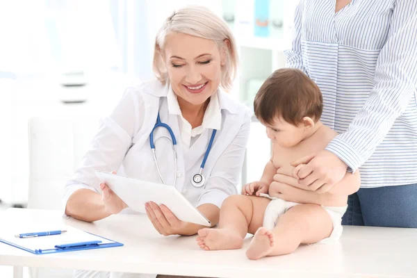 Femme mûre médecin examinant bébé garçon en clinique — Photo