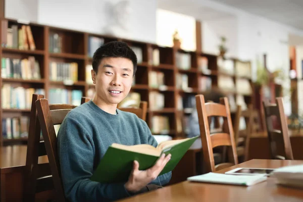 Asiática estudiante con libro estudiar en biblioteca — Foto de Stock
