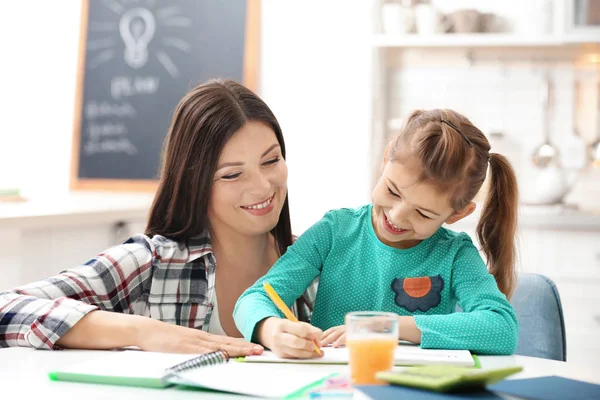 Little girl doing homework with parents — Stock Photo, Image