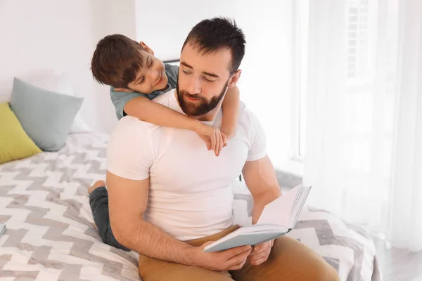 Отец читает книгу своему маленькому сыну дома — стоковое фото