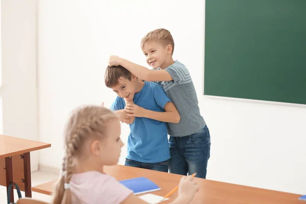 Маленький хлопчик знущається зі своїм однокласником у школі — стокове фото