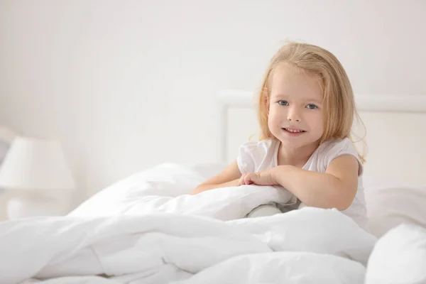 Bambina seduta sul letto — Foto Stock