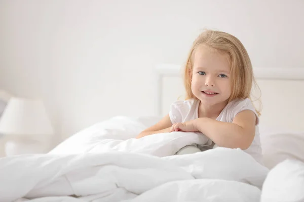 Meisje, zittend op bed — Stockfoto