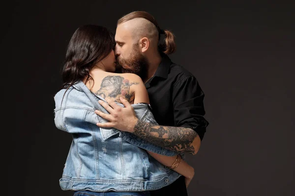 Unga par med tatueringar kyssar — Stockfoto