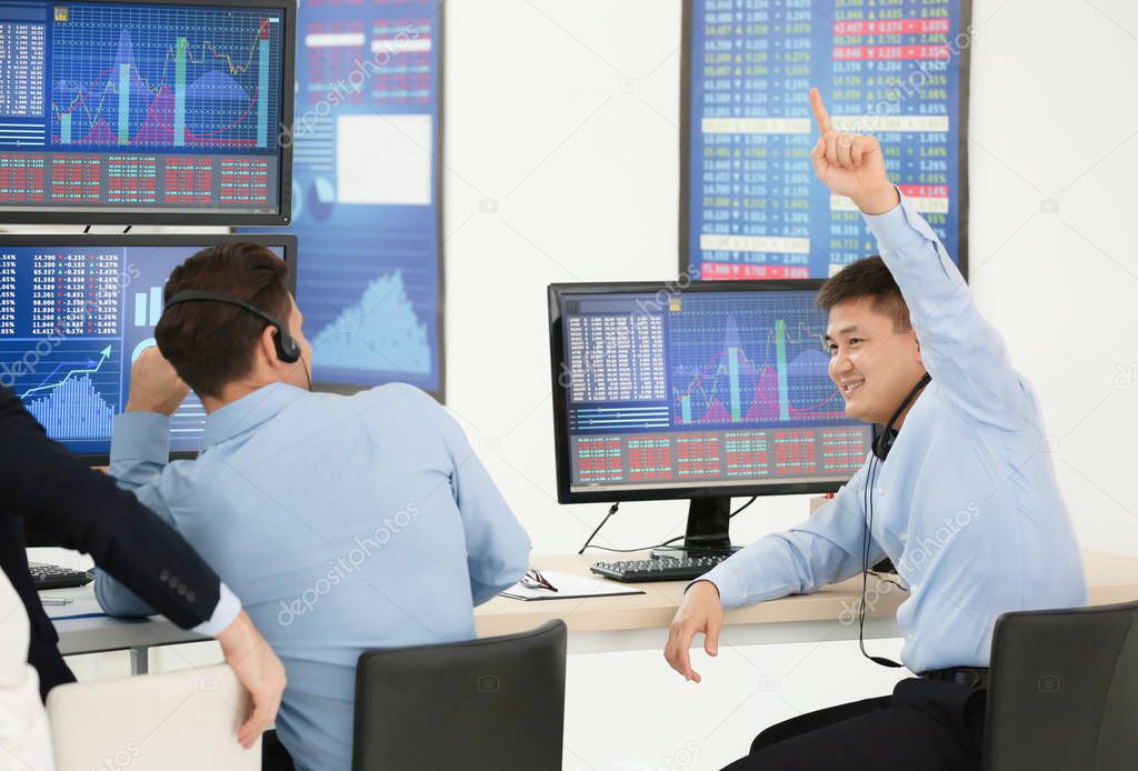 Male stock traders working in office