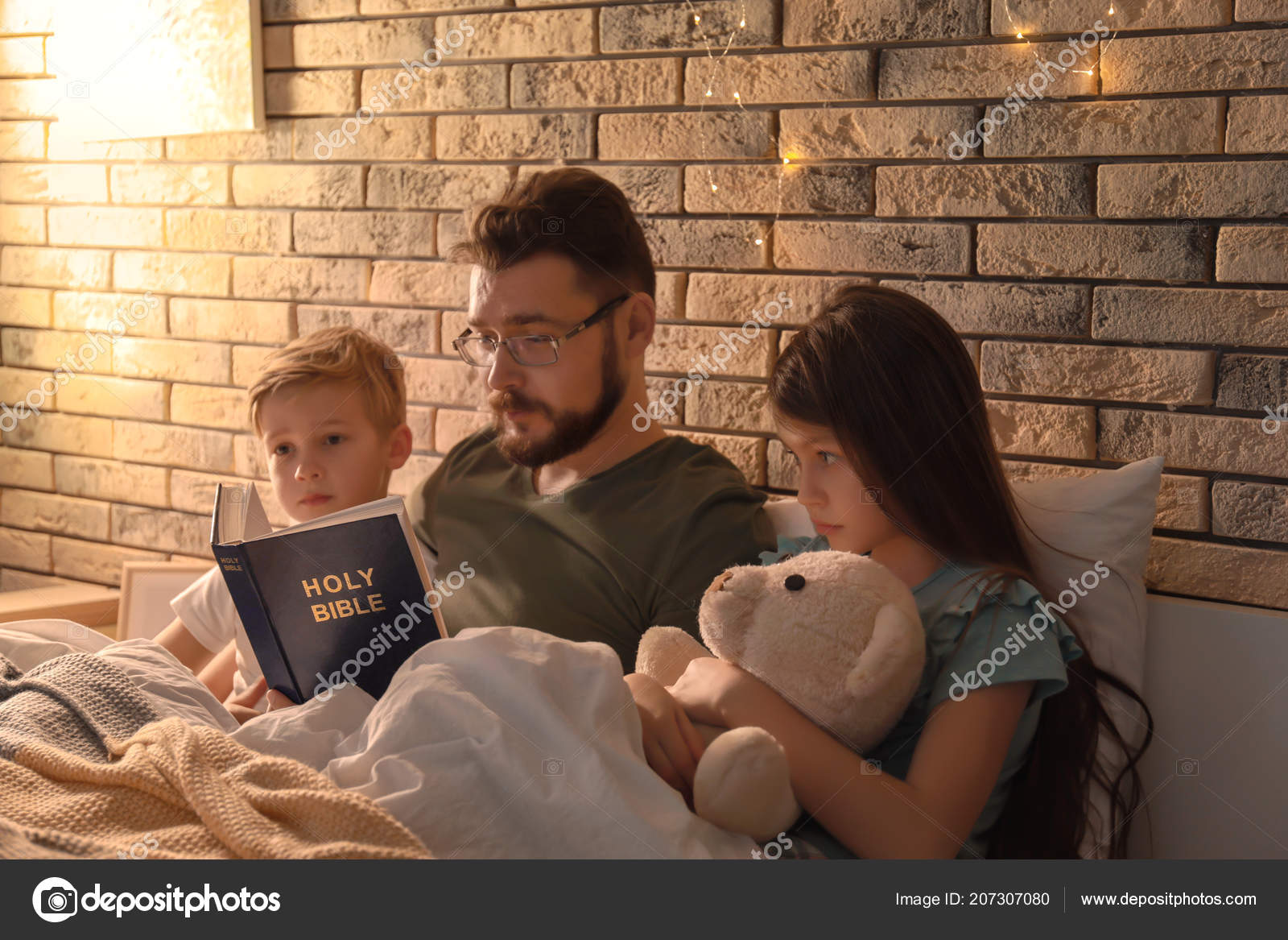 Mother reading bedtime story to her little children under blanket in  evening Stock Photo by ©belchonock 207307080