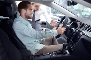 Bayilik yeni otomobilin sürücü koltuğunda oturan adam