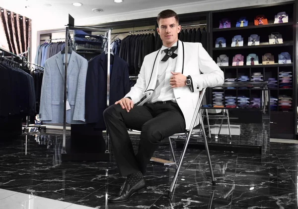 Handsome young man wearing elegant suit in shop — Stock Photo, Image