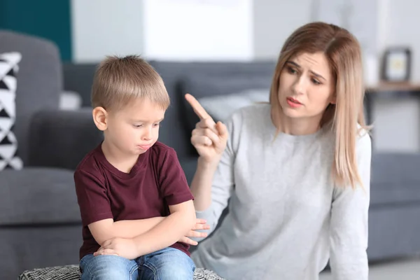 Mother scolding her little son at home