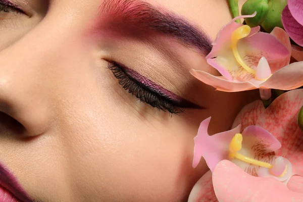 Jovem com sobrancelha tingida rodeada de flores — Fotografia de Stock