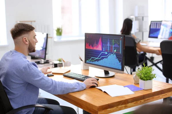 Hisse senedi verileri Office ile çalışan bir genç adam. Finans ticaret