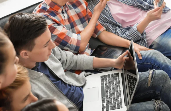 Grupo Adolescentes Con Dispositivos Modernos Sentados Sofá Interiores — Foto de Stock