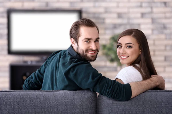 Νεαρό ζευγάρι που βλέπει τηλεόραση στο σπίτι — Φωτογραφία Αρχείου