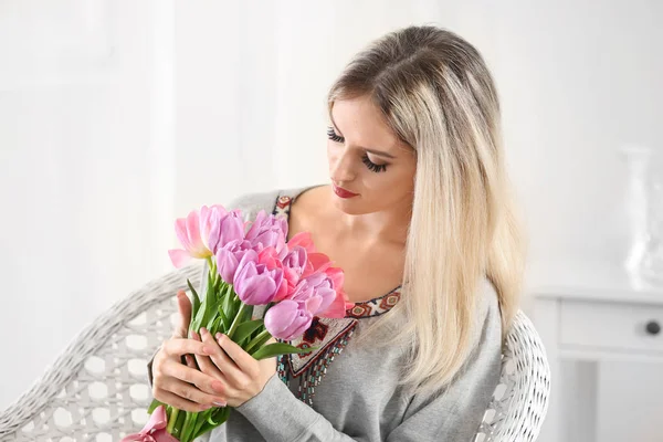 Mulher bonita com buquê de tulipas em casa — Fotografia de Stock