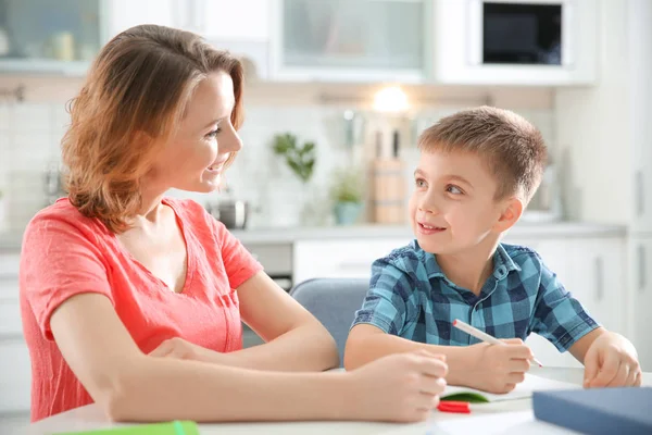 Niño pequeño con madre haciendo deberes en casa — Foto de Stock