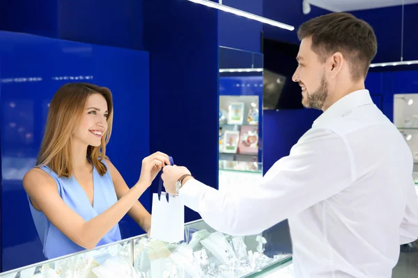 Junge Verkäuferin gibt Kundin im Juweliergeschäft Einkauf — Stockfoto