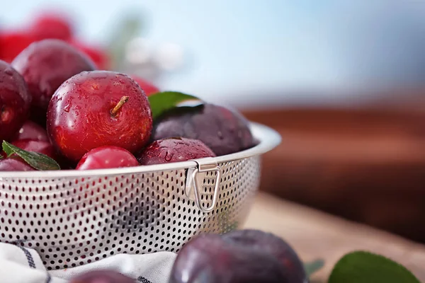 Strainer with ripe juicy plums — Stock Photo, Image