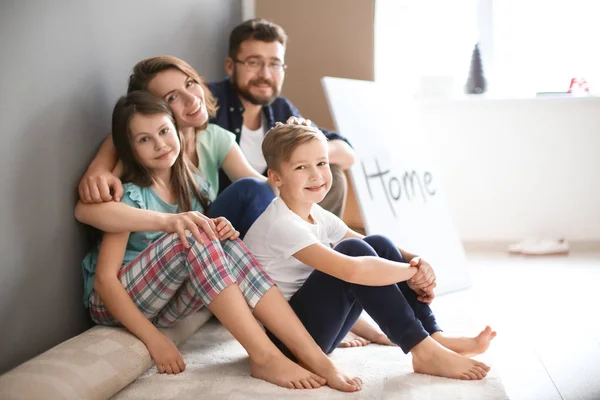 Couple with children sitting near boxes — Stock Photo, Image