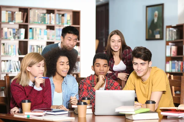 Grupp av studenter som studerar vid bord i biblioteket — Stockfoto