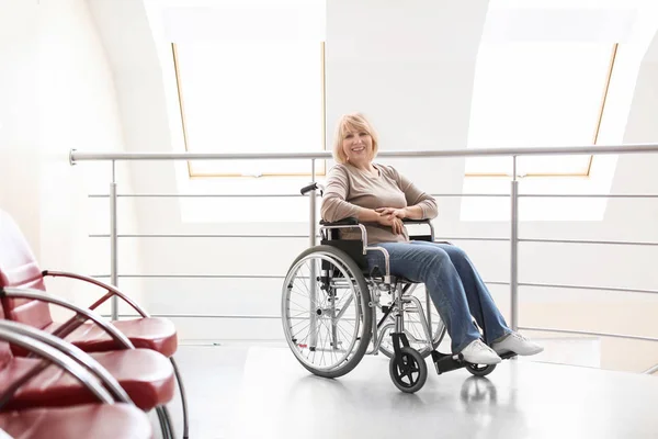 Male doctor taking care of mature woman in wheelchair indoors — Stock Photo, Image