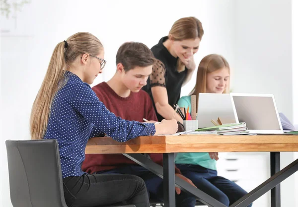 Grupo Adolescentes Haciendo Tarea Con Profesor Aula —  Fotos de Stock