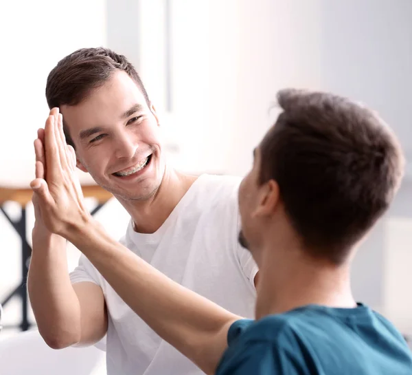 Hombres dando cinco de alto en el interior. Concepto de unidad — Foto de Stock