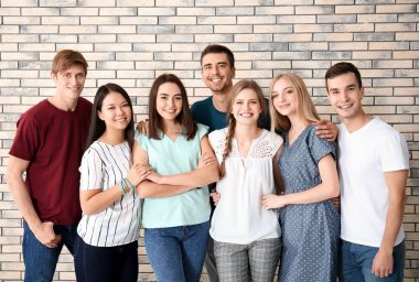 Birlikte tuğla duvara yakın duran insanlar. Birlik kavramı