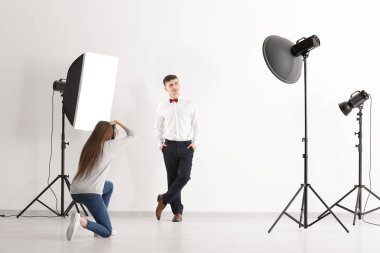 Genç adam Studio beyaz arka plan üzerinde profesyonel fotoğrafçı için poz