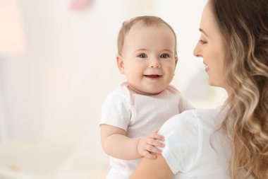Onun şirin bebek üzerinde arka plan bulanık ile Genç Anne