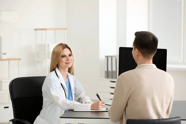 Médica Consultando Jovem Paciente Clínica — Fotografia de Stock