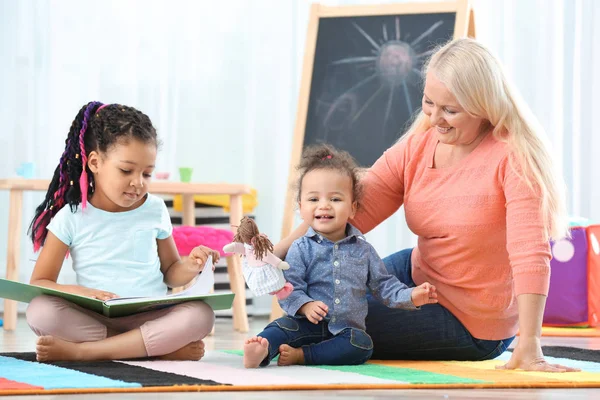 Reife Kindermädchen Helfen Kleinen Afrikanisch Amerikanischen Mädchen Bei Den Hausaufgaben — Stockfoto