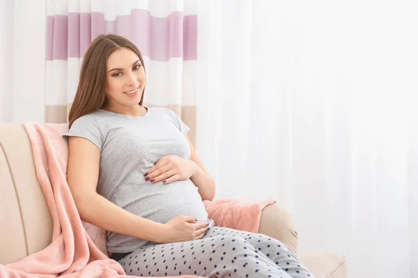 自宅のソファで休んで美しい妊娠中の女性の肖像画 — ストック写真