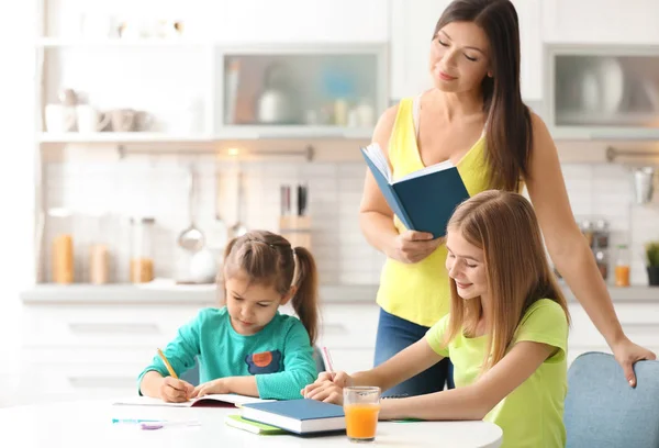 台所で母親と一緒に宿題をしてかわいい女の子 — ストック写真