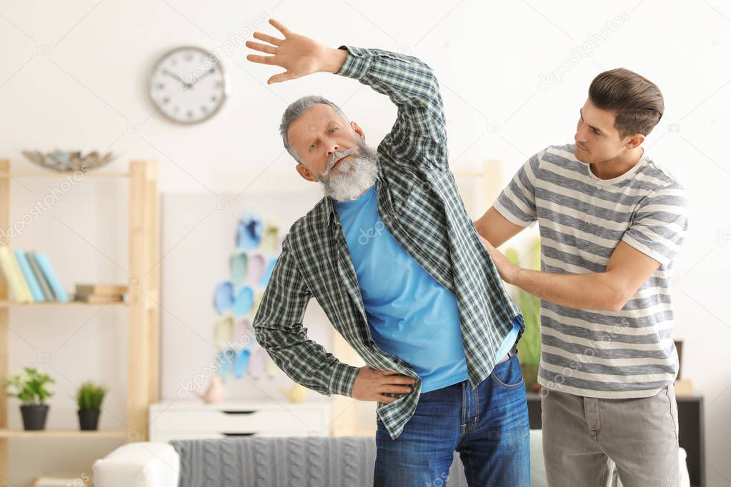 Senior man with young caregiver at home