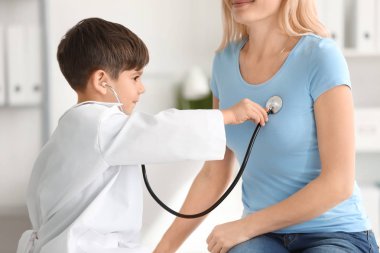 Sevimli küçük çocuk doktor Tekdüzen muayene hastada kapalı